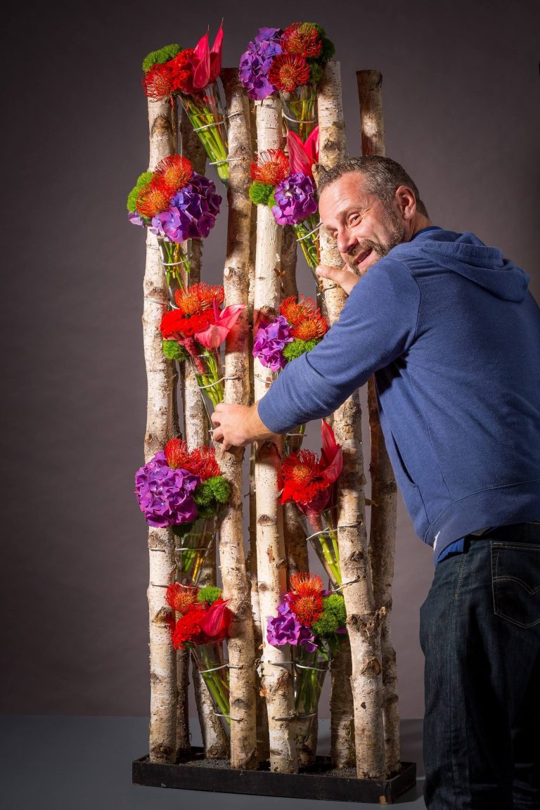 Walter Vermeulen holding a red and purple flower design